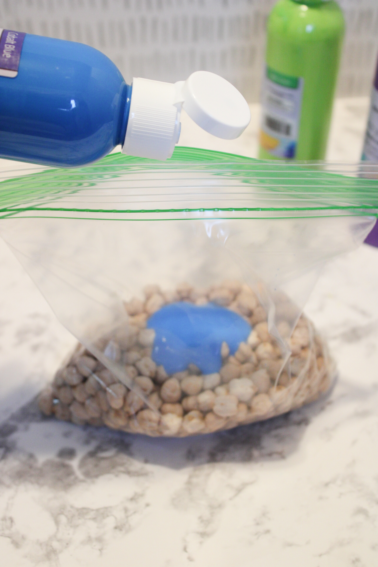 ziploc bag containing dried chickpeas and blue acrylic paint